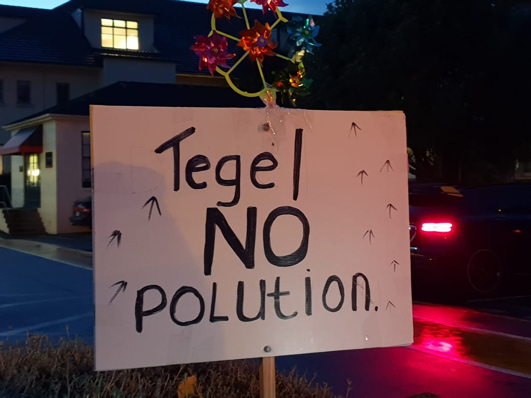 A sign reading 'no pollution' held by a protester at outside a hui held by Tegel in Auckland on Wednesday 6 June 2018.
