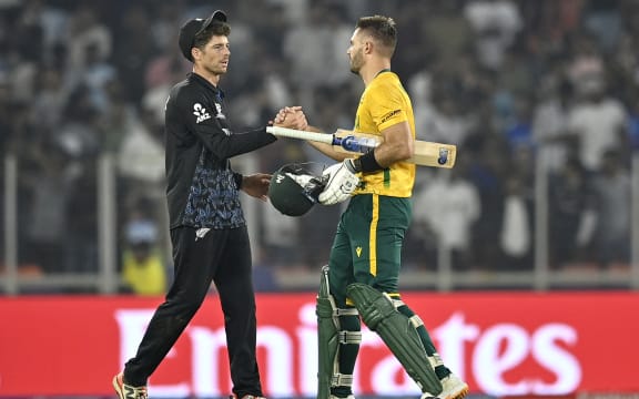 South Africa's captain Aiden Markram (R) is congratulated by his New Zealand counterpart Mitchell Santner for his team's win at the end of the 2026 ICC Men's T20 Cricket World Cup group stage match between New Zealand and South Africa in the Narendra Modi Stadium, Ahmedabad on February 14, 2026. (Photo by Shammi MEHRA / AFP)