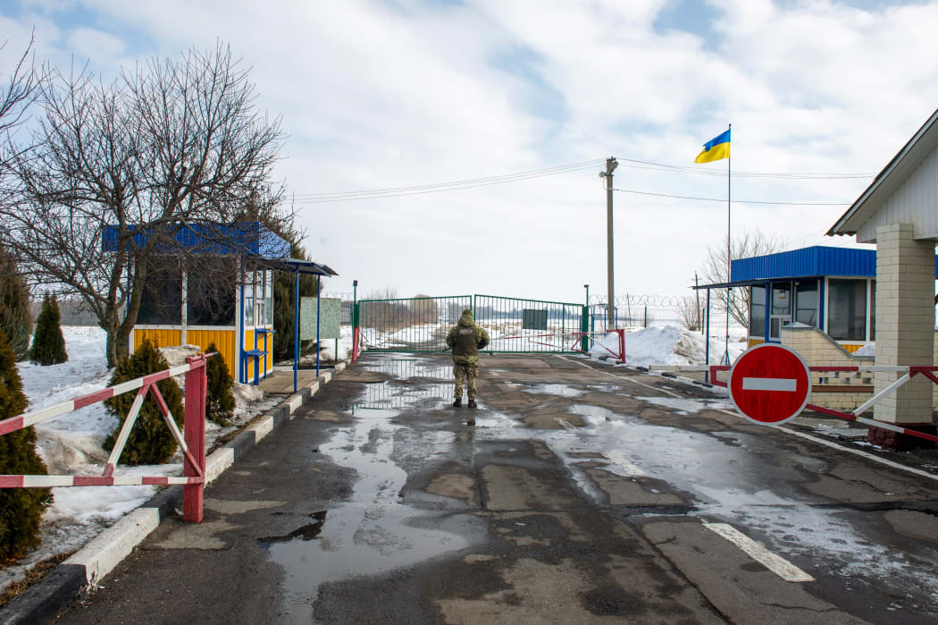 A Ukrainian frontier guard at a checkpoint on the border with Russia, some 40km from the second largest Ukrainian city of Kharkiv, 16 February 2022.