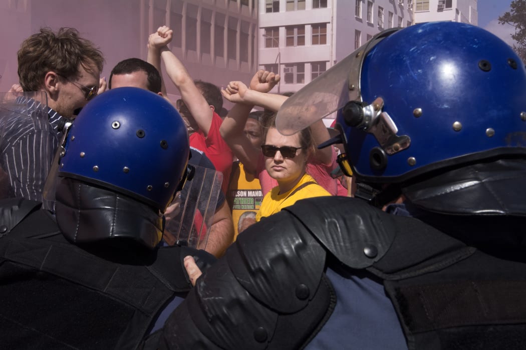 Students from the University of Cape Town stand facing members of the South African Police Services after they forced their way into the South African Parliament in Cape Town on October 21, 2015.