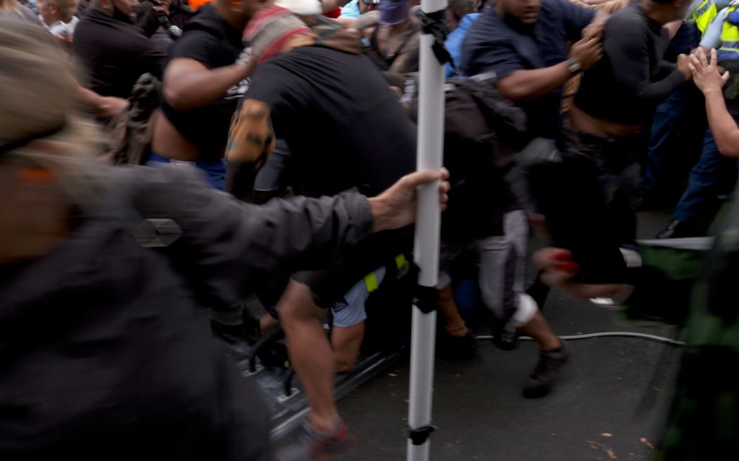 A police officer is dragged to the ground by protestors during police action on March 2nd, 2022.