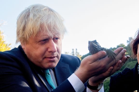 Boris Johnson inspects a tuatara during his visit to Zealandia wildlife sanctuary.