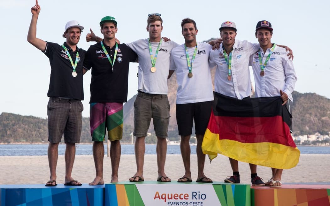 Peter Burling and Blair Tuke (centre) on the podium after winning gold at the Olympic Test Event, 2015.