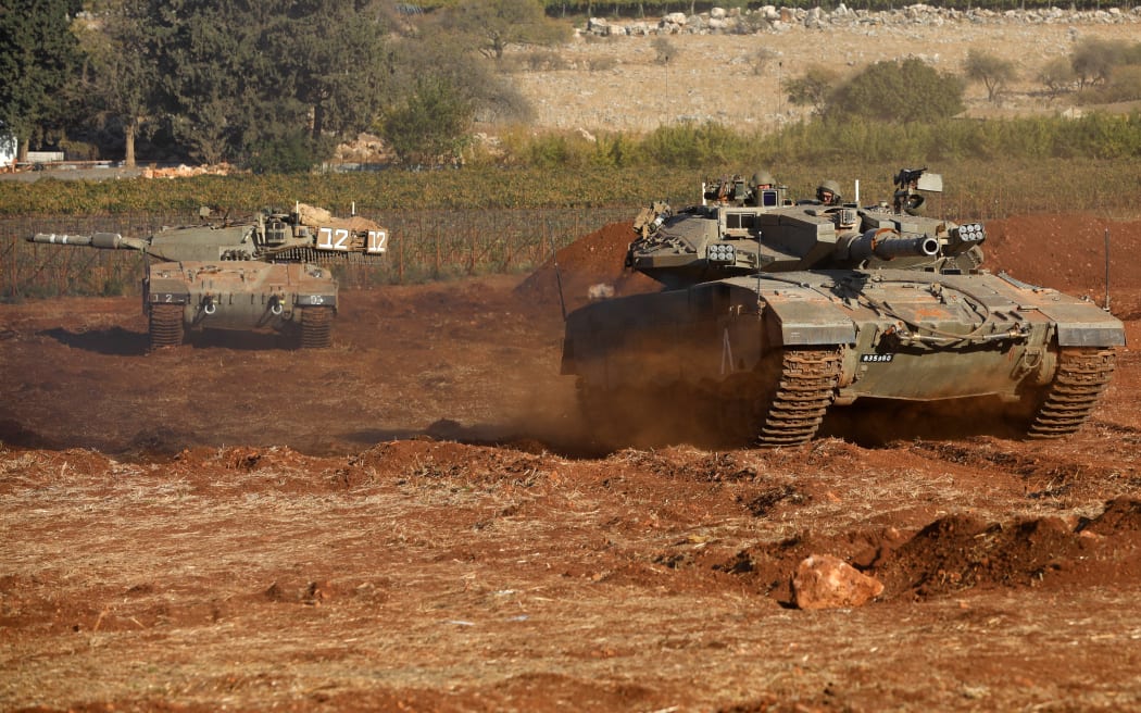 Israeli Merkava tanks take part in a military drill near the border with Lebanon in the upper Galilee region of northern Israel on October 26, 2023, amid the ongoing battles between Israel and the Palestinian group Hamas in the Gaza Strip. (Photo by Jalaa MAREY / AFP)