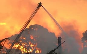 Firefighters extinguishing a large blaze at Parnell's City Garden Lodge on 7 April 2024.