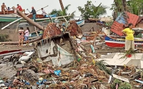 Residents surveying damage caused by heavy rain and floods in Oroquieta City.