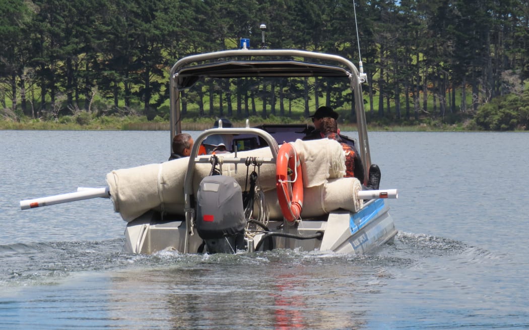 Divers and wool mats on board NRC vessel, Mangapai, heading to the egeria (oxygen weed) bed to lay the wool matting in Lake Rotokawau.