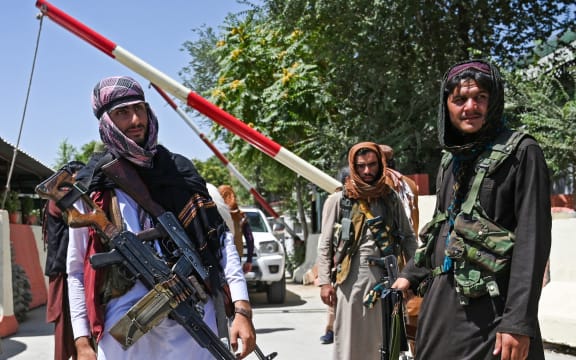 Taliban fighters stand guard along a roadside near the Zanbaq Square in Kabul on August 16