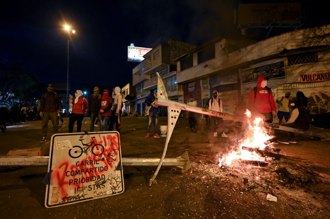 Demonstrators block a street with a barricade in Cali, Colombia during a protest against a tax reform bill.