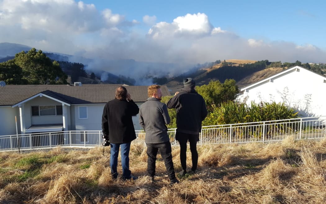 Henry Reese, centre, watches his family home burn.