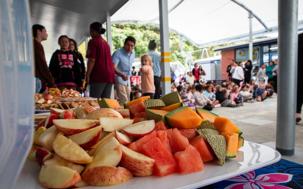 Children at Arakura School line up for free lunch