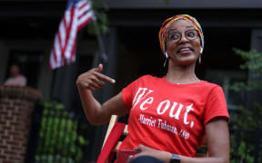 Janice Lloyd points to a quote that reads "We out" on her T-shirt as she watches a parade to celebrate Juneteenth in Annapolis, Maryland.
