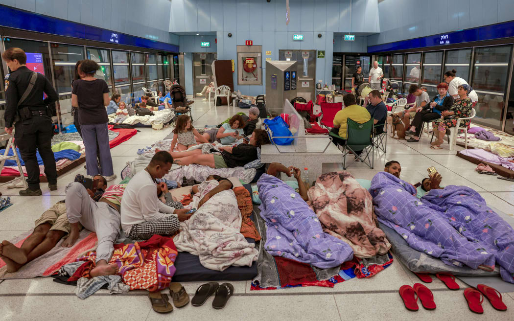 People take shelter for the night at an underground light rail station in the city of Ramat Gan, east of Tel Aviv, on June 17, 2025 amidst fears of an Iranian missile attack. (Photo by Menahem Kahana / AFP)