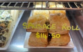A sausage roll for sale in a cafe for $14.50.