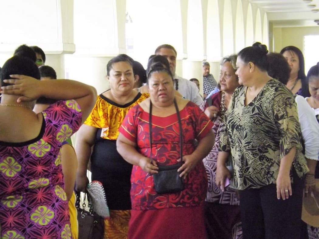 Luse Emo Tauvale (centre wearing the red puletasi) leaves the courthouse in Apia.