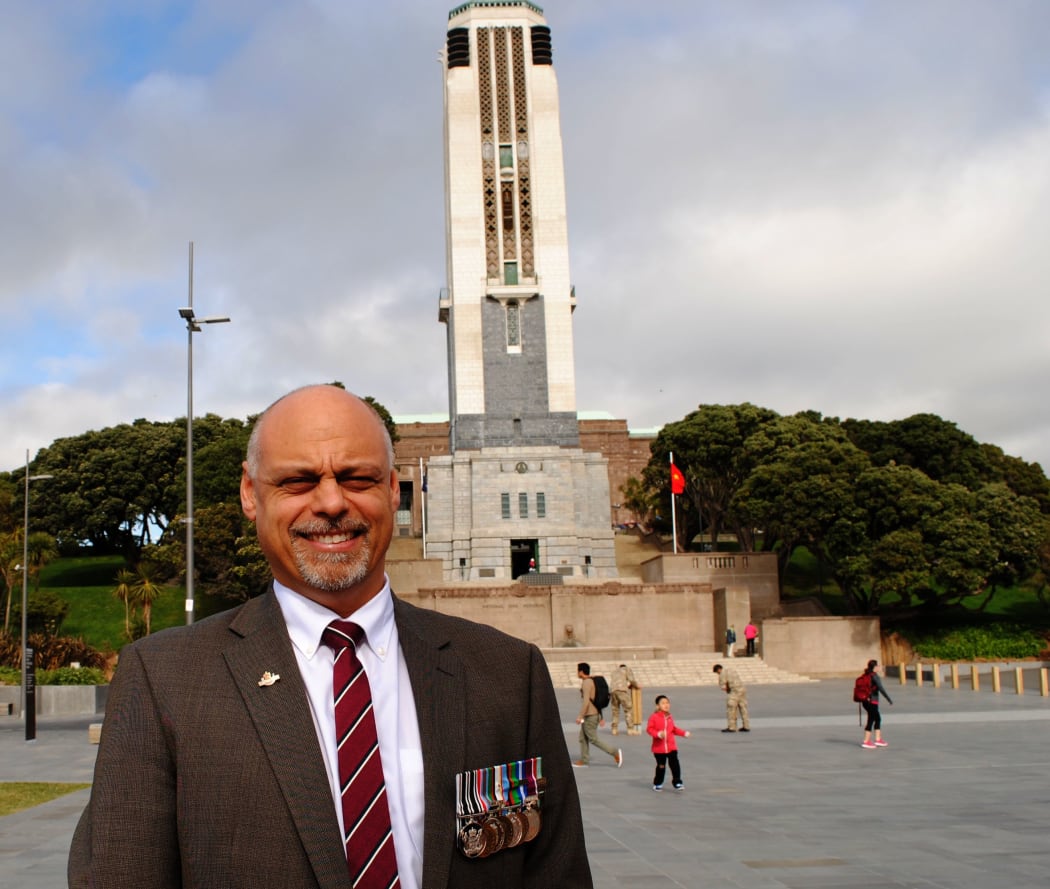 RSA manager of support services, Mark Compain stands in front of the national war memorial carillion at Pukeahu in Wellington. He is wearing war medals
