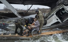 A woman on wheelchair leaves the city of Irpin during the evacuation during the Russia-Ukraine War, on March 7, 2022 (