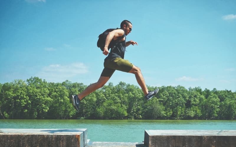 Man leaping over a gap in a walkway