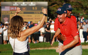 Keegan Bradley celebrates with wife Jillian Stacey and team-mate Tony Finau after the US Team beat the International Team in the Presidents Cup.
