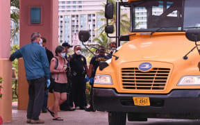 Some of the people who are under quarantine at Hotel Santa Fe Guam in Tamuning board a bus to be moved to a new location. Monday 23 March.