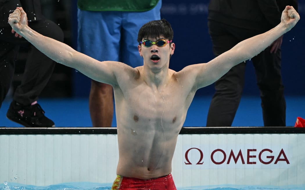 China's Pan Zhanle reacts after winning gold and breaking a world record in the final of the men's 100m freestyle swimming event during the Paris 2024 Olympic Games at the Paris La Defense Arena in Nanterre, west of Paris, on July 31, 2024. (Photo by Jonathan NACKSTRAND / AFP)