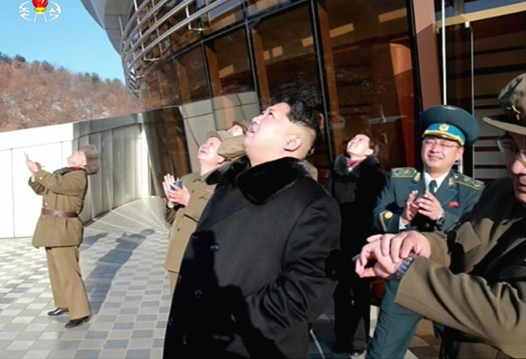 North Korean TV showed Kim Jong-Un, centre, watching the rocket launch.