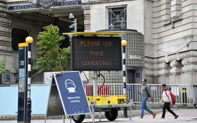 A sign tells passengers to 'wear a face covering' at Waterloo train station in central London during the Covid-19 pandemic
