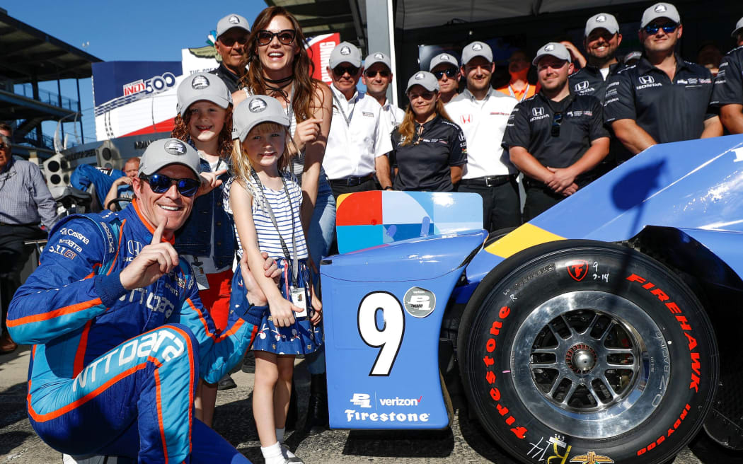Scott Dixon with places the Verizon P1 Pole Award sticker with his wife Emma, daughters Tilly and Poppy, and the Honda team at Indianapolis Motor Speedway.