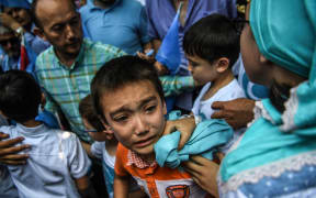 A boy reacts as Turkish plain clothes police officers try push back demonstrators during a protest of supporters of the mostly Muslim Uighur minority and Turkish nationalists to denounce China's treatment of ethnic Uighur Muslims.