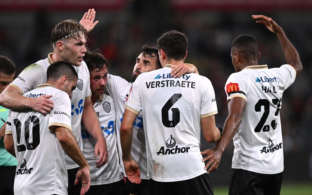 Lachlan Brook of Auckland (third left) celebrates with teammates after scoring a goal.