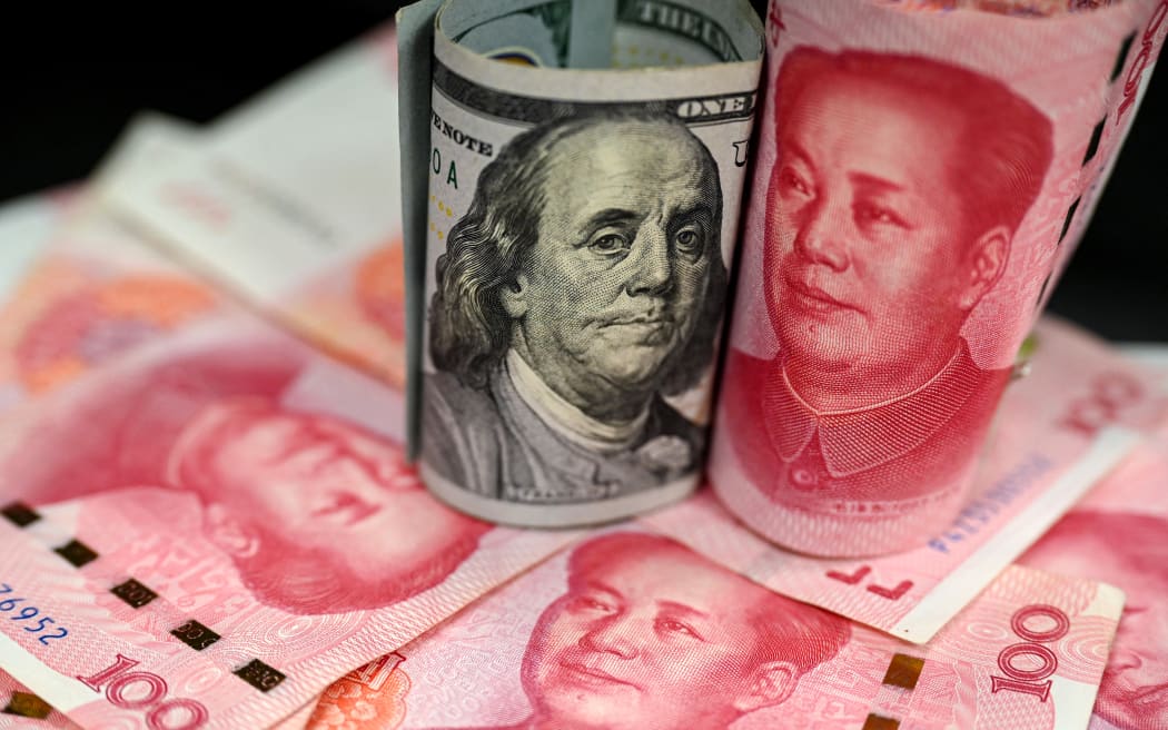 This photo illustration shows Chinese 100 yuan notes (red) and US 100 dollar notes, in Beijing on April 8, 2025. China vowed on April 8 to "fight to the end" against fresh tariffs of 50 percent threatened by US President Donald Trump, further aggravating a trade war that has already wiped trillions off global markets. (Photo by Jade GAO / AFP)