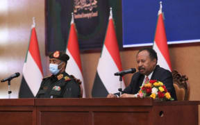 General Abdel Fattah al-Burhan, left, and Sudanese Prime Minister Abdalla Hamdok appeared on TV to sign a power-sharing agreement.