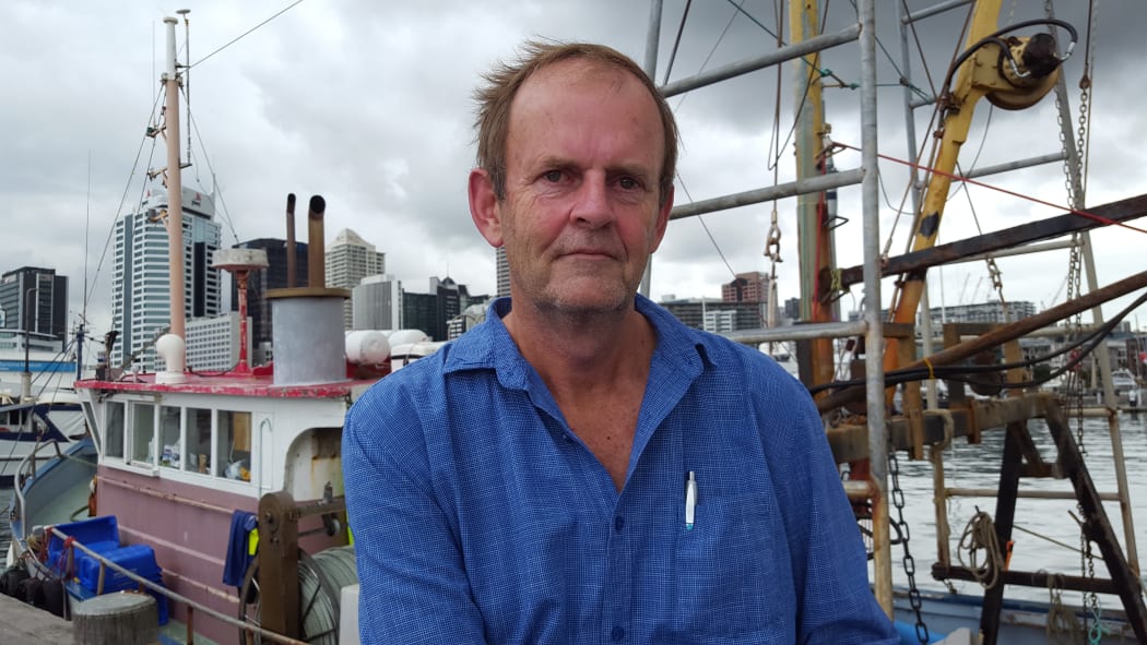 Auckland University researcher, Dr Glenn Simmons in front of fishing boats at Auckland harbour