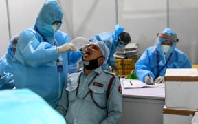 Medical staff taking a swab sample from a man at Dr Ram Manohar Lohia (RML) hospital in New Delhi on 31 July.
