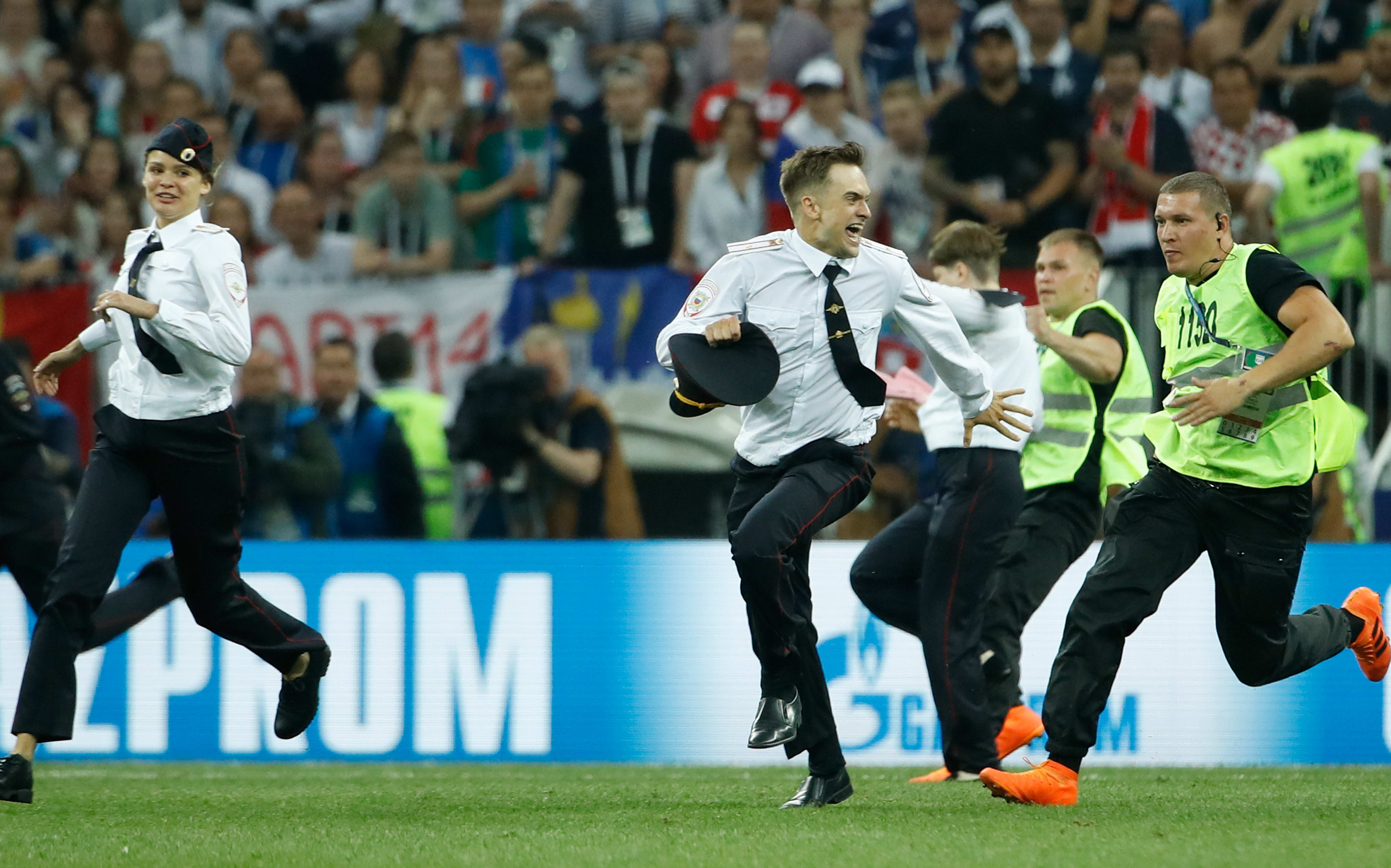 Stewards remove pitch invaders during the Russia 2018 World Cup final football match between France and Croatia at the Luzhniki Stadium in Moscow on July 15, 2018.