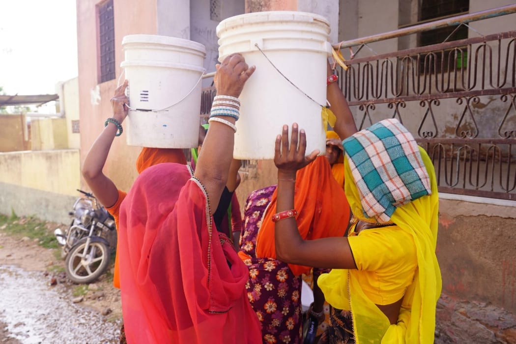 Indian Villagers collects drinking water from a road side water tap during a hot summer day on the outskirts Village of Ajmer, Rajasthan, India on 11 June 2021. (Photo by Himanshu Sharma/NurPhoto) (Photo by Himanshu Sharma / NurPhoto / NurPhoto via AFP)