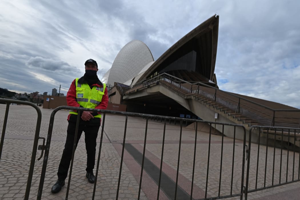 A security guard stands in front of the Sydney Opera House in Circular Quay, during lockdown in Sydney, Australia, Friday, July 23, 2021.