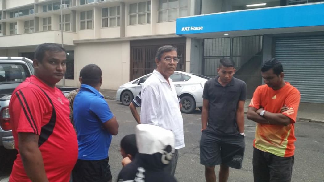 Attar Singh's lawyer Raman Singh (white shirt) outside the central police station in Suva.