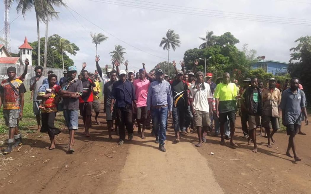 Samuel Winggu (centre) leading people in Daru.