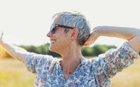 Enthusiastic senior woman with arms outstretched in sunny field. (Photo by CAIA IMAGE / SCIENCE PHOTO LIBRA / NEW / Science Photo Library via AFP)