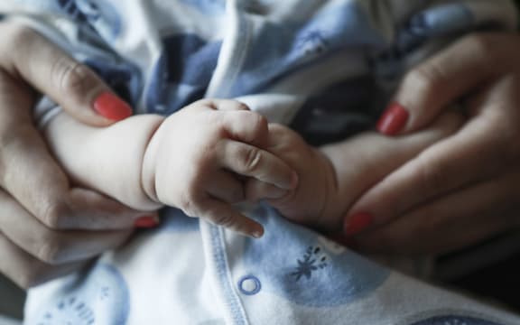 Hands of baby and mother