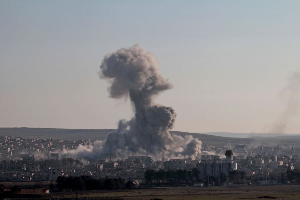 Smoke rises after a US-led coalition air strike on IS targets in Kobane in Syria (December 2014).