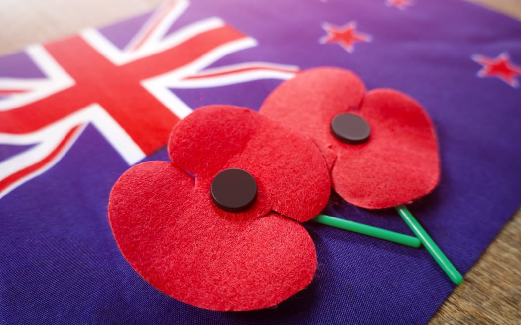 Close up on Remembrance poppies on a New Zealand flag.