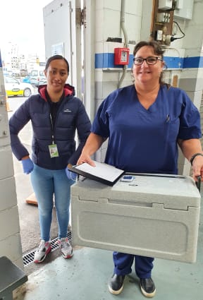 Hospital Security person Irene and registered nurse Wendy Thompson deliver the first of the COVID-19 vaccines to the Sulphur Point.