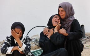 Women cry as they mourn the death of a loved one killed during overnight Israeli bombardment on June 12, 2025, at Al-Shifa hospital in Gaza City, amid the ongoing war between Israel and the Palestinian Hamas militant group. (Photo by Omar AL-QATTAA / AFP)