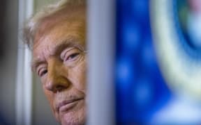 US President Donald Trump speaks to journalists aboard Aire Force One as he travels from West Palm Beach back to Washington on March 9, 2025. (Photo by ROBERTO SCHMIDT / AFP)