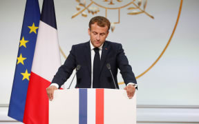 TOPSHOT - French president Emmanuel Macron delivers a speech during a ceremony in memory of the Harkis, Algerians who helped the French Army in the Algerian War of Independence, at the Elysee Palace in Paris, on September 20, 2021.