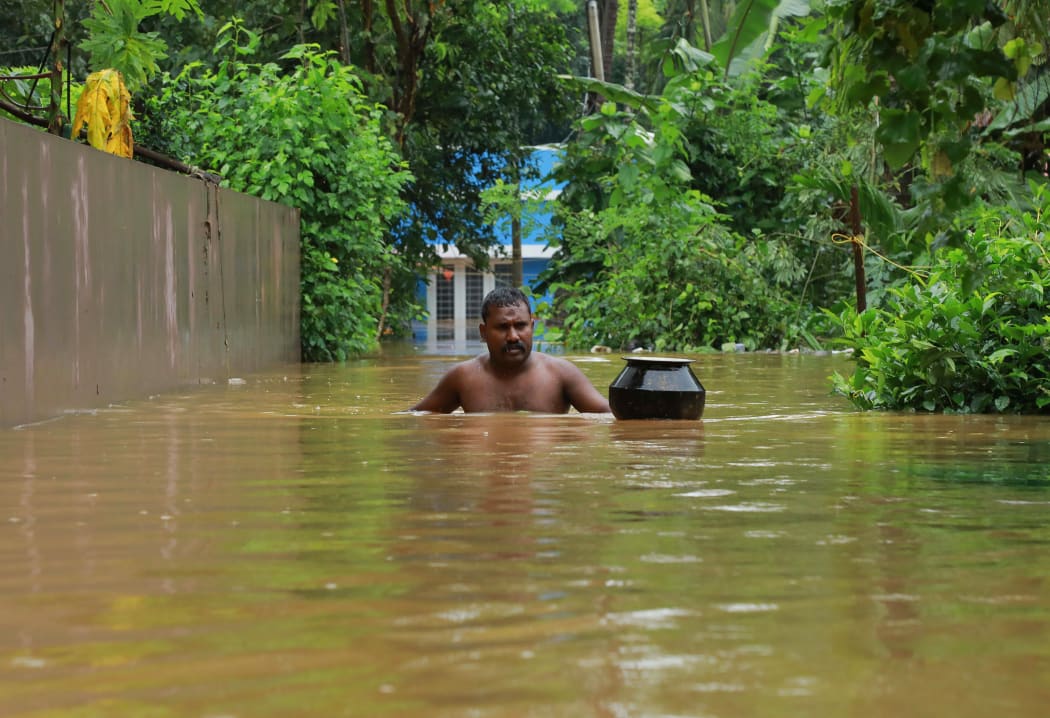 A man walks in flood waters at Eloor area in Ernakulam district, in the south Indian state of Kerala.