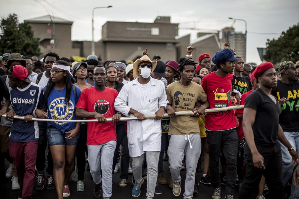 Demonstrators march through the campus of the University of the Witwatersrand in Johannesburg on October 21, 2015,