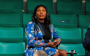 Tennis star Serena Williams watches a game from the stands.